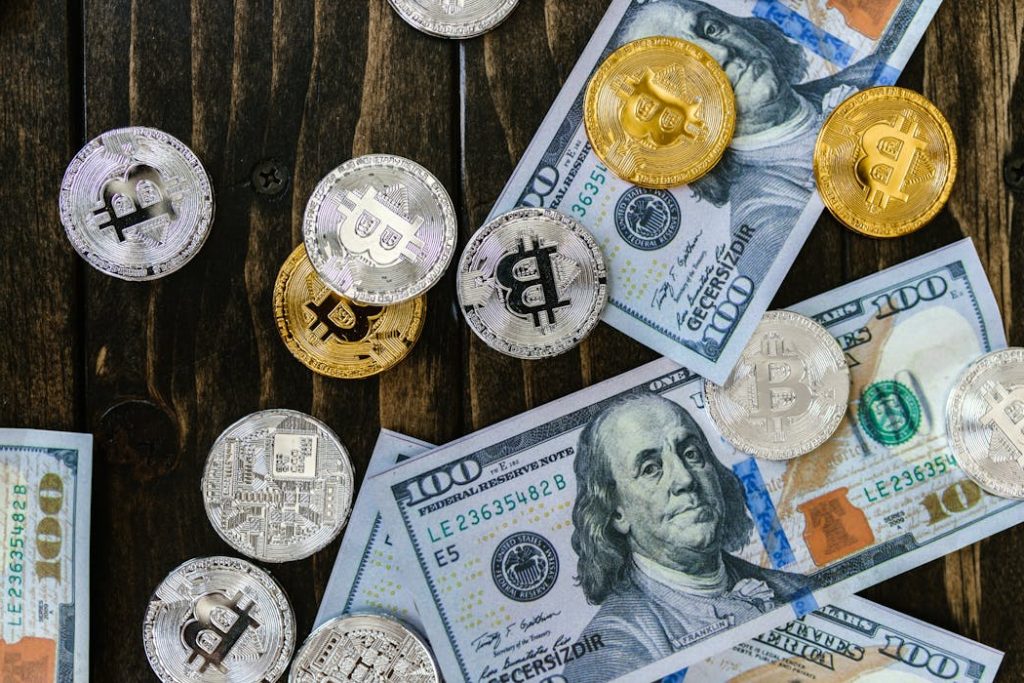 US Dollars and Bitcoin Tokens Scattered on a Wooden Table